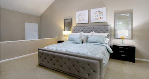 Huge master bedroom with vaulted ceiling and loft style layout with attached master bathroom and walk-in closet at Woodlake on the Bayou Apartments in Houston.