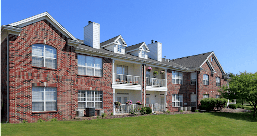 Luxury apartments with red brick exteriors, spacious balconies, lush landscaping, and scenic views at Saddlebrook apartments in Urbandale Iowa