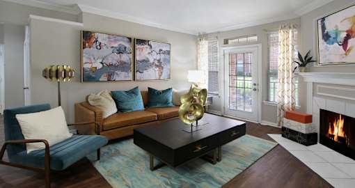 Spacious living room with wood-burning fireplace and French door at Saddlebrook apartments in Urbandale Iowa
