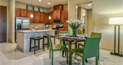 Luxury apartments next to the Galleria in Dallas with granite countertops, stainless steel appliances, built-in wine rack, kitchen island, and porcelain tile floor at Villa Piana Apartments in Dallas