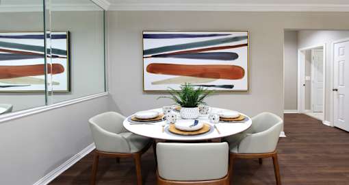 Spacious dining room with mirror accent wall at Saddlebrook apartments in Urbandale Iowa