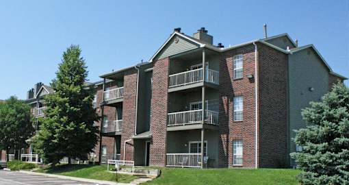 Apartments with brick exteriors, beautiful landscaping, lush landscaping, scenic views, large balconies, spacious balconies, at Alpine Village Apartments in La Vista, Nebraska