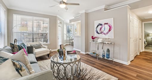 Spacious living room with wood plank floors, French door, and oversized windows at The Saxony Apartments in Dallas