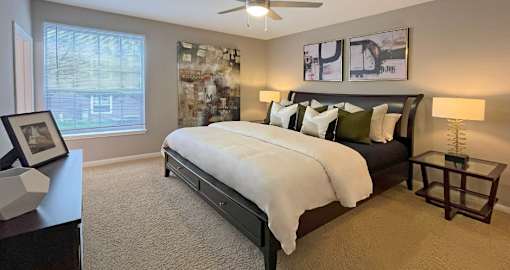 Spacious master bedroom with walk-in closet, attached master bathroom, and ceiling fan at Breckenridge Apartments in Omaha, Nebraska