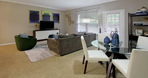 Apartments in southwest Omaha with spacious layout, open floor plan, oversized windows, and gray wall color at Breckenridge Apartments