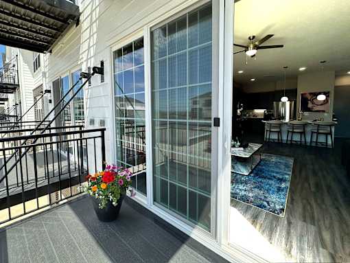 A patio with a table, chairs, and a potted plant.