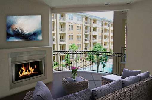 Large spacious balcony with patio fireplace and pool view at Tuscany Walk Apartments in Houston Texas.