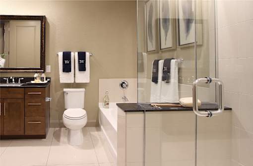 Luxury apartments with spacious bathrooms with oval soaking tub, separate shower with glass enclosure, and granite slab vanity top Tuscany Walk Apartments in Houston.