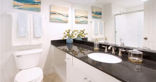 Luxury bathroom with oval soaking tub with glass enclosure, granite vanity top, and glass shower at Tuscany Villas Townhomes in Houston.