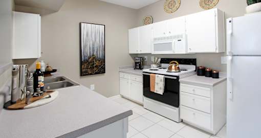 Bright white kitchen with porcelain tile floors at Breckenridge Apartments in Omaha, Nebraska