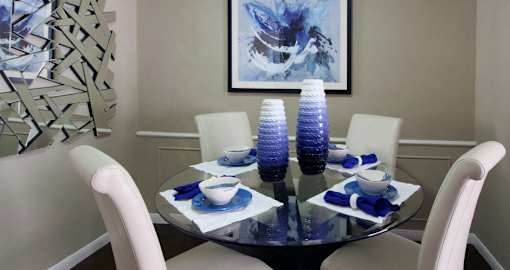 a dining room with a glass table and white chairs