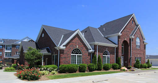 Luxury apartments with red brick exteriors, beautiful landscaping, and scenic views at Rockledge Oaks Apartments in Lincoln, Nebraska