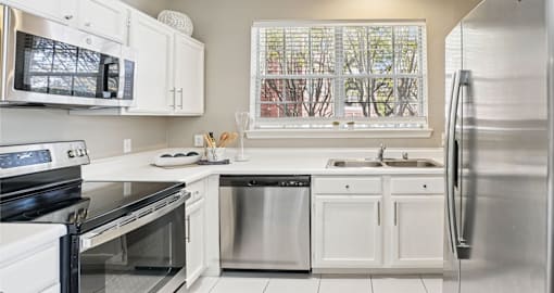 Luxury apartments with kitchens with white cabinets and stainless-steel appliances at The Saxony Apartments in Dallas