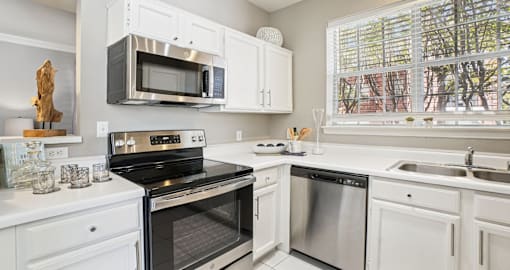 Luxury apartments with kitchens with white cabinets and stainless-steel appliances at The Saxony Apartments in Dallas