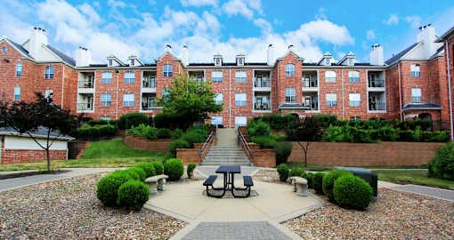 Luxury apartments with red brick exteriors, lush landscaping, landscaped courtyard, and beautiful grounds at TurtleCreek Apartments in West Des Moines