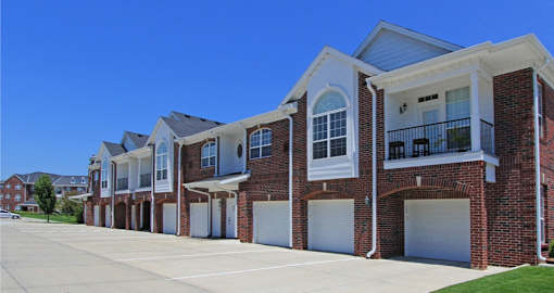 A row of townhouses with garages on the side.