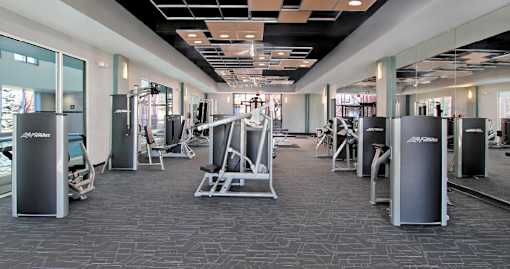 A gym with a variety of equipment including weights and machines.
