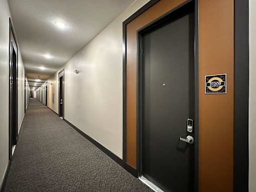 A hallway with a door on the right and a sign on the door.