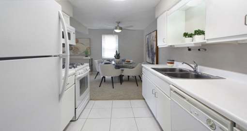 Bright white kitchen with lots of cabinet space, porcelain tile floor, and spacious dining room at Inwood Apartments in La Vista, Nebraska