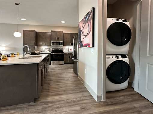 A modern kitchen with dark wood cabinets and a white countertop.