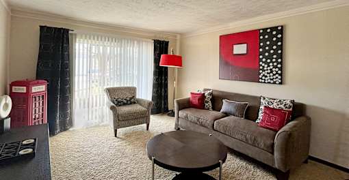 Spacious living room with sliding glass doors, extra-large windows with lots of natural light at Kensington Woods Apartments
