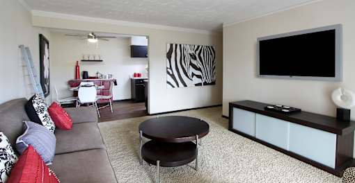 Spacious living room, dining room and kitchen with wood laminate flooring at Kensington Woods Apartments