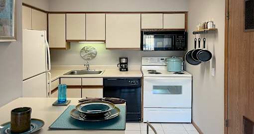 Fully-equipped kitchen with lots of cabinet space, built-in breakfast bar and tiled floors at LionsHead Apartments in Omaha Nebraska