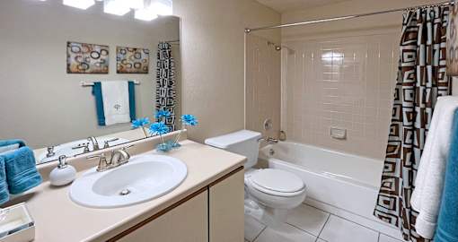 Spacious bathroom with tiled shower, tiled floors, lots of cabinet space, and extra storage space at LionsHead Apartments in Omaha Nebraska