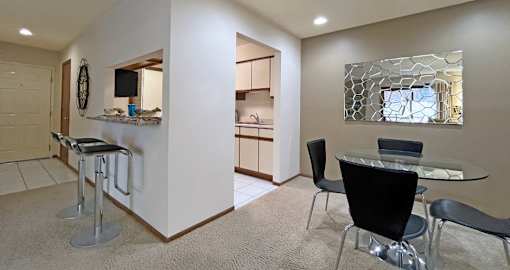 Dining room area with painted feature wall, granite breakfast bar, and kitchen with tiled floor at LionsHead Apartments in Omaha Nebraska