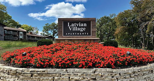 the sign apartments in front of red flowers