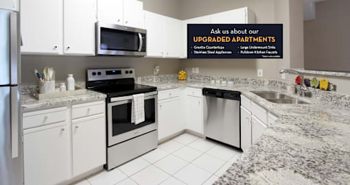 Spacious kitchen with white cabinets, granite countertops, stainless steel appliances, and porcelain tile floors at Breckenridge Apartments in southwest Omaha, Nebraska