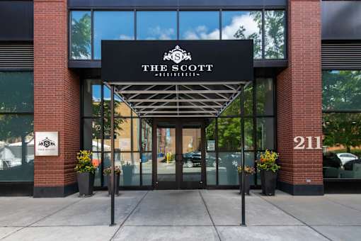 The entrance to a building with a sign that reads "The Scott".