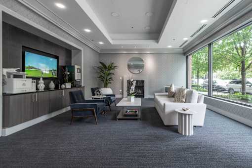 A modern living room with a large screen TV and comfortable seating.