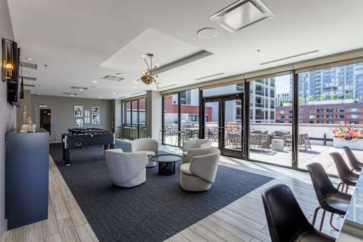 A modern living room with a ceiling fan and large windows.