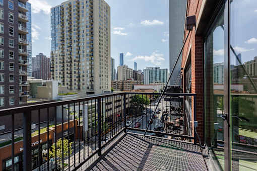 A balcony with a black railing overlooks a cityscape.