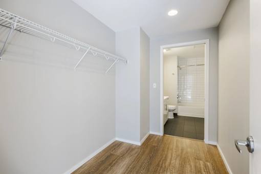 A white wall with a white door and a white shelf.