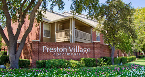 Luxury apartments in north Dallas with beautiful landscaping, scenic views, and red brick exteriors at Preston Village Apartments