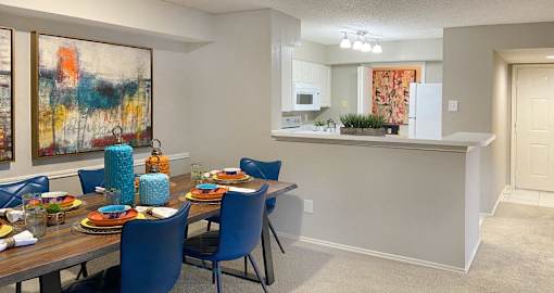 Spacious apartments with dining room and kitchen with white cabinets at Preston Village Apartments in north Dallas
