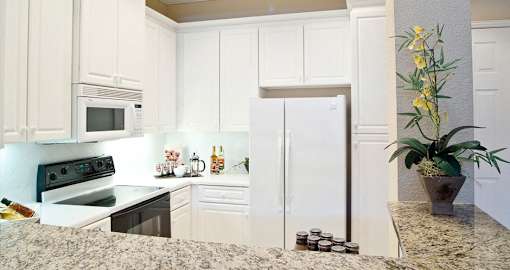 Luxury apartments with white cabinets, bright white kitchens, granite breakfast bar, and side-by-side refrigerator at RidgeGate Apartments in Minnetonka, Minnesota