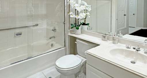 Luxury bathroom with tiled floors, oval soaking tub, built-in vanity, cultured marble vanity, glass shower and white cabinets in at Saddlebrook apartments in Urbandale Iowa