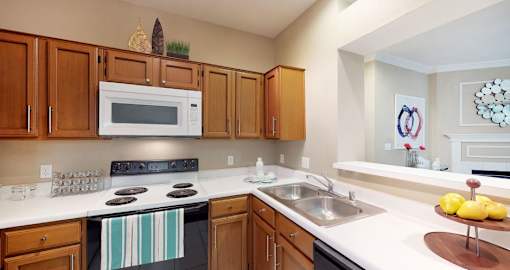 A kitchen with wooden cabinets and a black stove top oven.