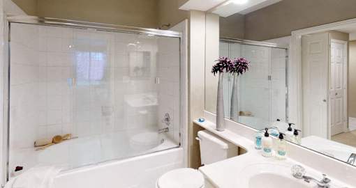 Luxury apartments with spacious bathrooms with glass showers, oval soaking tubs, and cultured marble vanities at Tuscany Gate Apartments in Houston.
