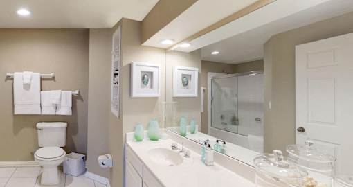 Luxury apartments with spacious bathrooms with glass showers, oval soaking tubs, built-in shelves, spacious linen closets, and cultured marble vanities at Tuscany Gate Apartments in Houston.