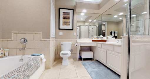 Luxury apartments with oval soaking tub, separate glass shower, built-in vanity, and cultured marble vanity top at RidgeGate Apartments in Minnetonka, Minnesota