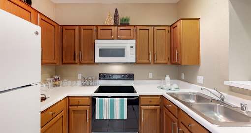 a kitchen with wooden cabinets and a stove and a sink