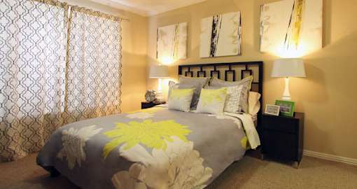 Spacious bedroom with walk-in closet and ceiling fan at Tuscany Oaks Apartments in Houston.