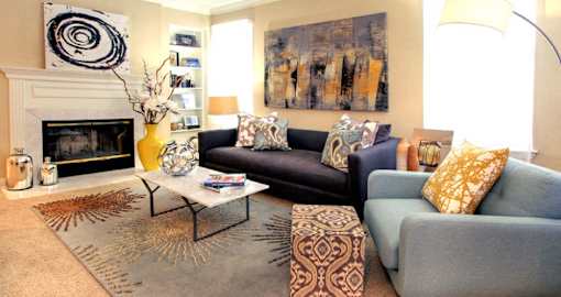 Spacious living room with wood-burning fireplace, built-in bookshelves, crown molding, and 9-foot ceilings at Tuscany Oaks Apartments in Houston.