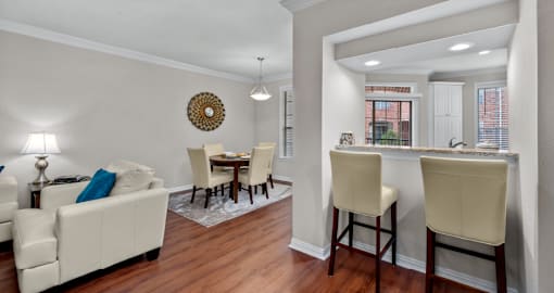 Spacious dining room with built-in bookshelves, hardwood floors, breakfast bar, and French doors at Tuscany Villas Apartments in Houston.