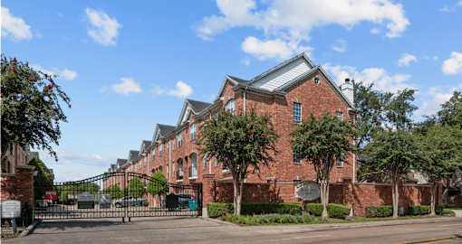 Luxury townhomes in a gated community with red brick exteriors and attached 2-car garages at Tuscany Row Townhomes in Houston.