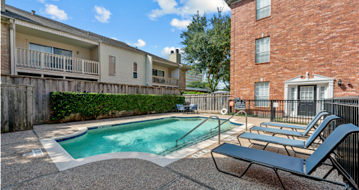 Luxury townhomes with swimming pool and poolside lounge seating at Tuscany Row in Houston.
